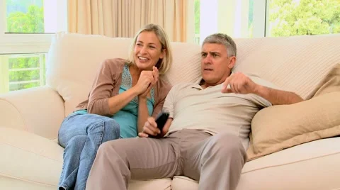 Couple on sofa delighted with programme on TV Stock Footage 2872511