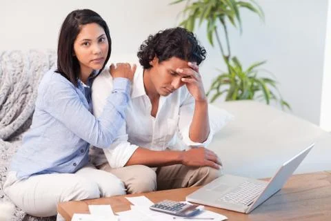 Couple on the sofa doing their calculations Stock Photos