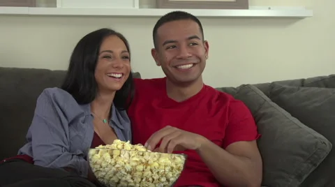 Couple on sofa eating popcorn Stock Footage 44112902