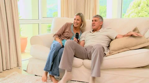 Couple on sofa ecstatic as they watch a programme on TV Stock Footage 2872613
