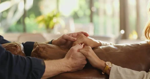 Couple, sofa or holding hands with sympathy for trust, commitment or comfort Stockbeeldmateriaal 310506421