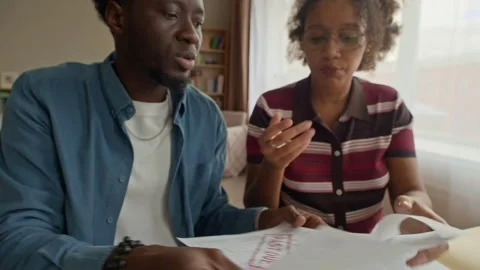 Couple Sorting Bills and Receipts in Folder While Organizing Finances at Home Stock Footage 321861604