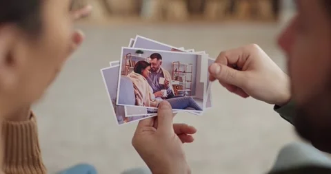 Couple sorting printed photos together, reflecting on memories and past moments Stock Footage 331196781