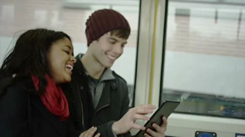 A couple spend quality time while riding the bus and playing with their tablet Stock Footage 34017388