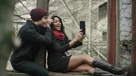 A couple spend time together in the park playing with their tablet Stock Footage 34017053