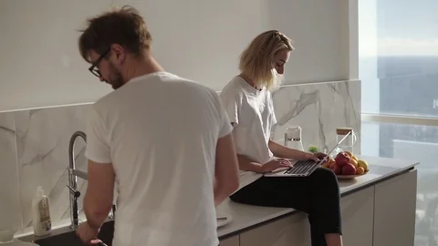 Couple spending time together in talk at the kitchen. Blonde woman using a Stock Footage 123468266