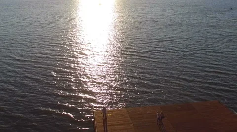 Couple staing on the pier at sunset. Shooting with quadrocopters. Dron. dji Stock Footage 67487213