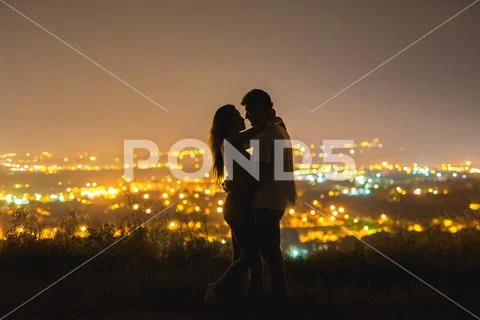 The couple stand on the background of the city lights. night time Stock Photos