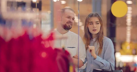 Couple is standing and discussing something next to the shopping window in the Stock Footage 95952144