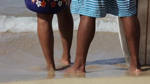 Couple standing barefoot on a beach. 库存影片 88367574