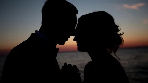 Couple standing on the beach at sunset. Slow motion Stock Footage 70587766