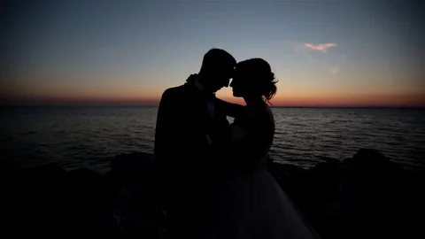 Couple standing on the beach at sunset. Slow motion Stock Footage 70588538
