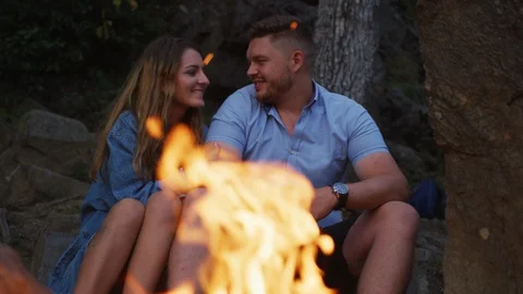 Couple standing by a campfire, looking up Stock Footage 99967133