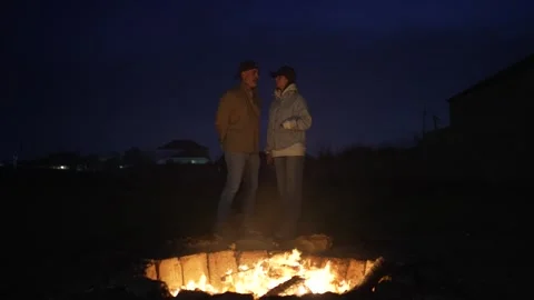Couple Standing by a Campfire at Night Stock Footage 306733061