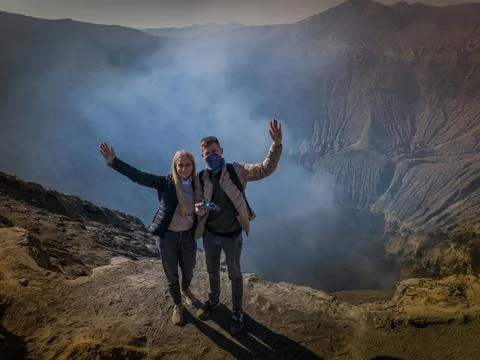 Couple standing on the edge of active volcano crater Bromo, Indonesia Stockfoto's