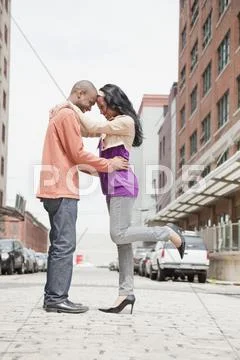 Couple standing face to face on urban street Stock-Fotos