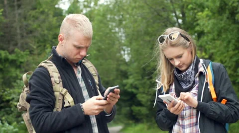 Couple standing in the forest and using smartphone in silence Video stock 67577274