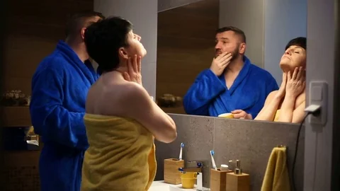 Couple standing in front of the mirror in the bathroom and checking  Stock Footage 73753568