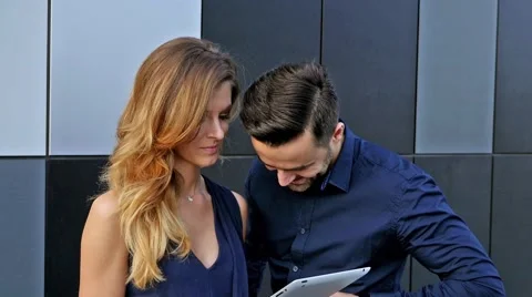 Couple standing in front of modern building with tablet pc. Positive emotions Stock Footage 55391338
