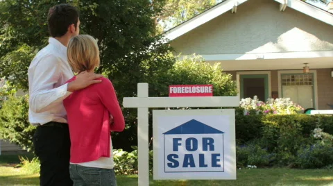 Couple standing in front of their foreclosed home Stock Footage 849206
