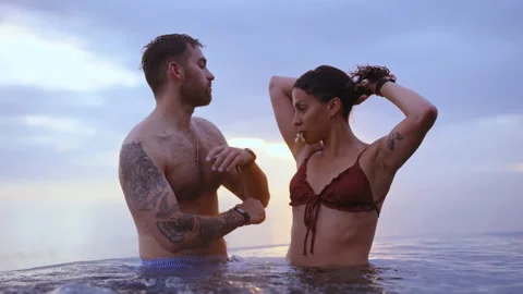Couple Standing at an Infinity Pool in the Backdrop of Gleaming Sunset Stock Footage 158859489