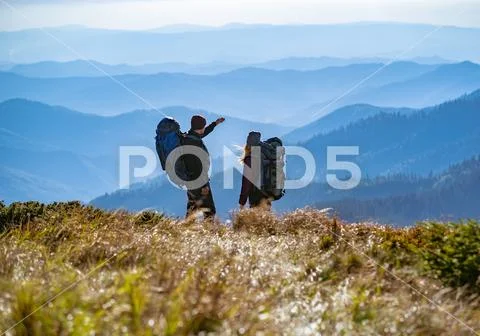 The couple standing on the mountain with a beautiful view Stock Photos