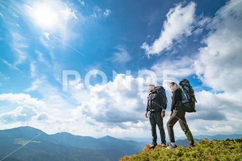 The couple standing on the mountain with a picturesque cloudscape Stock Photos