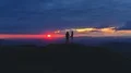 The couple standing on the mountain on a sunrise background 4k or 4k+ Resolution