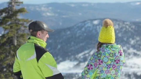 Couple standing in mountains in winter Stockbeeldmateriaal 73477900