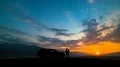 The couple standing near a car against the beautiful sunset 4k or 4k+ Resolution
