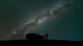 The couple standing near a car against sky with stars. time lapse 4k or 4k+ Resolution