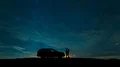 The couple standing near a car on the starry sky background. time lapse 4k or 4k+ Resolution