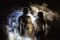 The couple standing near the smoke in the dark Photo