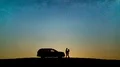 The couple standing near vehicle against the sunset. time lapse 4k or 4k+ Resolution