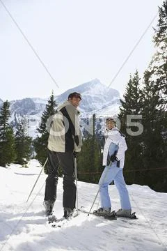 Couple Standing On Ski Slope Stock Photos