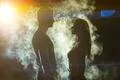 The couple standing in the smoke on a bright light background Photo
