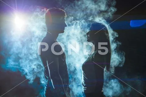 The couple standing in the smoke on a bright light background Stock Photos