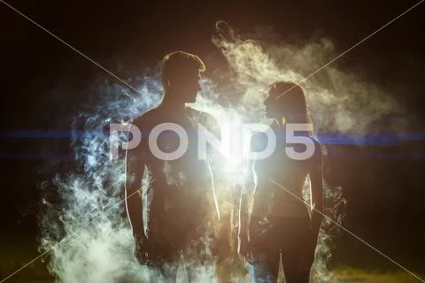 The couple standing in the smoke on a bright light background Stock Photos