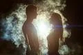 The couple standing in the smoke on a bright light background Photo