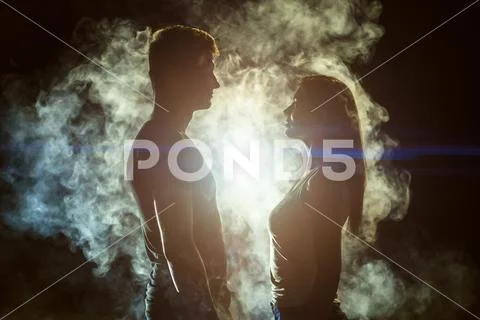 The couple standing in the smoke on a bright light background Stock Photos