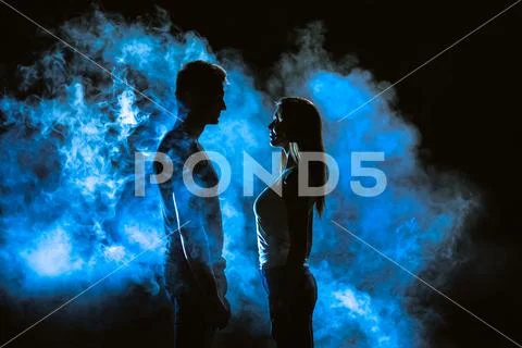 The couple standing in smoke on the dark background Stock Photos