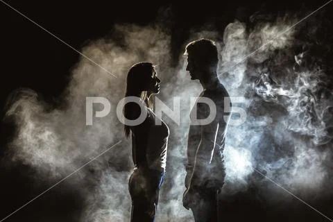 The couple standing in smoke on the dark background Stock Photos