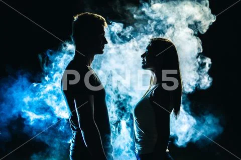 The couple standing in smoke on the dark background Stock Photos