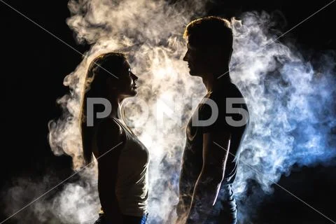The couple standing in smoke on the dark background Stock Photos