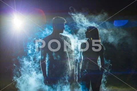 The couple standing in the smoke on a dark street Stock Photos
