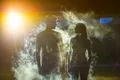 The couple standing in the smoke on a dark street Photo