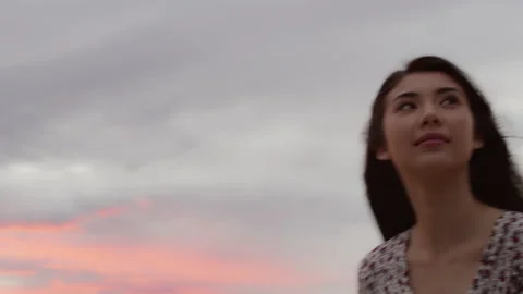 Couple standing together on the beach looking out at the water at sunset. 4k RED Stock Footage 199458997