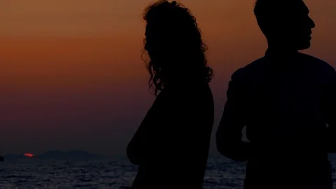 Couple standing together looking at red sun of the sunset in Zadar Stock Footage 89160464
