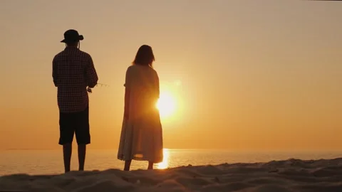 Couple standing together on sandy beach watching golden sunset over calm se.. Vídeos de archivo 334638939