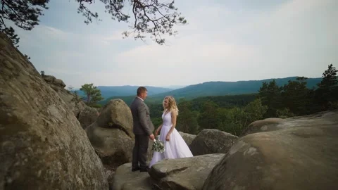 Couple standing on top of mountain. Strong wind and sunset. Stock Footage 233525209
